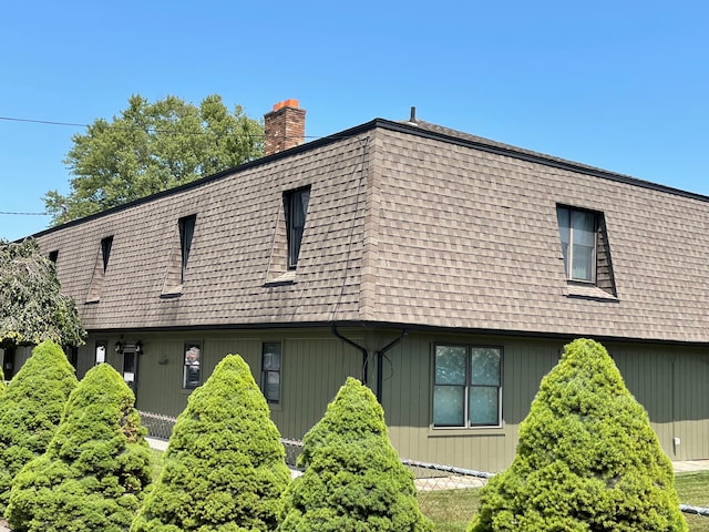 46070 Edgewater Dr, Chesterfield, MI 48047 - view of home's exterior with a chimney, roof with shingles, and mansard roof