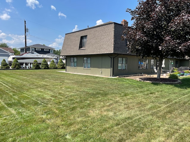 46070 Edgewater Dr, Chesterfield, MI 48047 - back of house with a shingled roof, mansard roof, a lawn, and a chimney