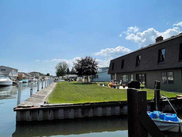 dock area with a lawn and a water view