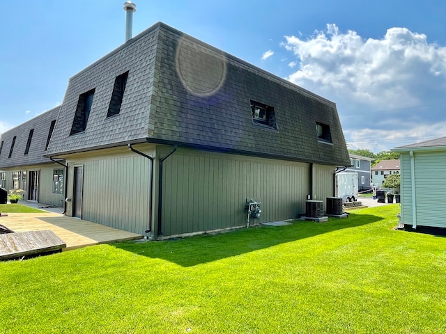 view of property exterior with a lawn and central air condition unit