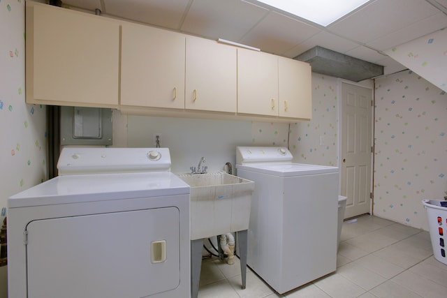 clothes washing area featuring cabinets, light tile patterned flooring, and washing machine and clothes dryer