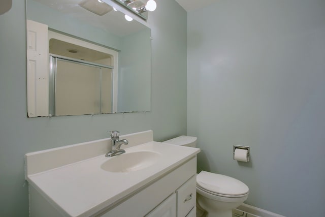 bathroom with an enclosed shower, vanity, and toilet