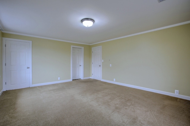 unfurnished room with crown molding and light colored carpet