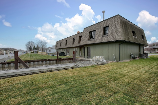 back of property with a yard and central AC unit