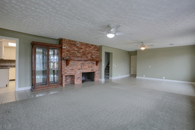 unfurnished living room featuring a textured ceiling, ceiling fan, light tile patterned floors, and a fireplace