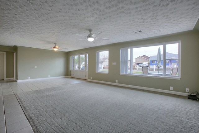 carpeted spare room featuring a textured ceiling and ceiling fan