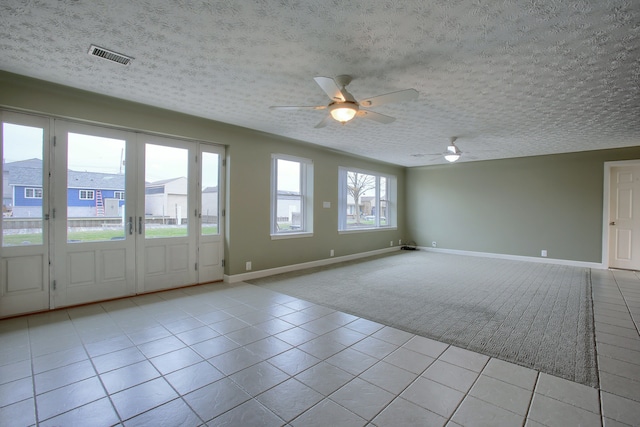 46070 Edgewater Dr, Chesterfield, MI 48047 - empty room featuring light tile patterned flooring, ceiling fan, a textured ceiling, baseboards, and light carpet