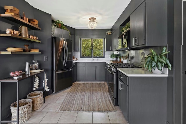 kitchen featuring gray cabinets, light tile patterned floors, and stainless steel appliances