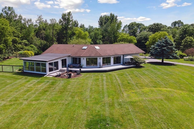 back of house with a sunroom and a lawn