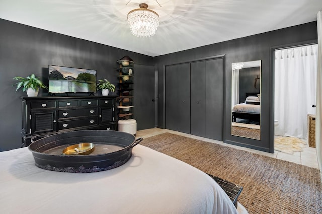 tiled bedroom featuring a closet and a chandelier