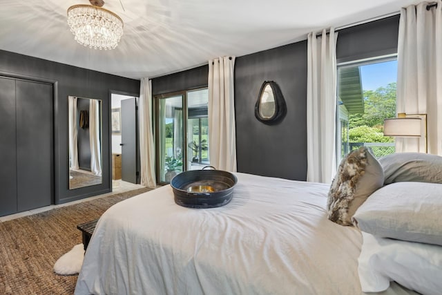 bedroom featuring a notable chandelier, a closet, access to exterior, and multiple windows