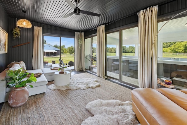 sunroom / solarium featuring a wealth of natural light, ceiling fan, and wooden ceiling