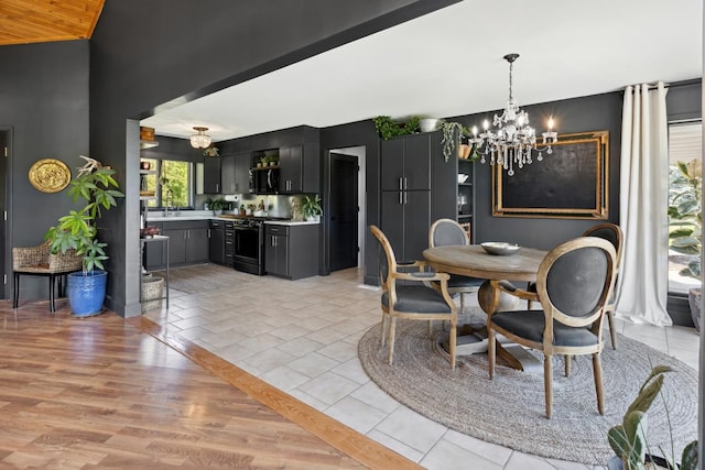 dining space with a wealth of natural light, sink, an inviting chandelier, and light wood-type flooring