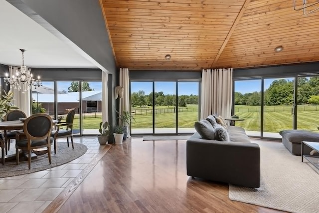 living room featuring hardwood / wood-style floors, plenty of natural light, a notable chandelier, and wood ceiling