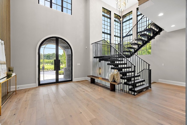 foyer entrance featuring french doors, a high ceiling, and light hardwood / wood-style flooring