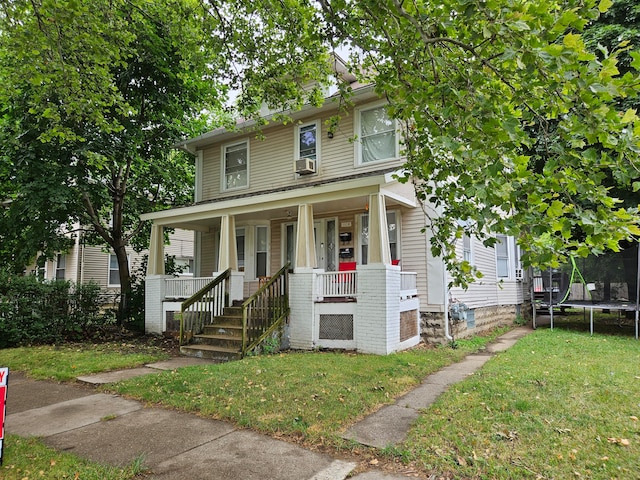 view of front facade with a front yard, a porch, and a trampoline