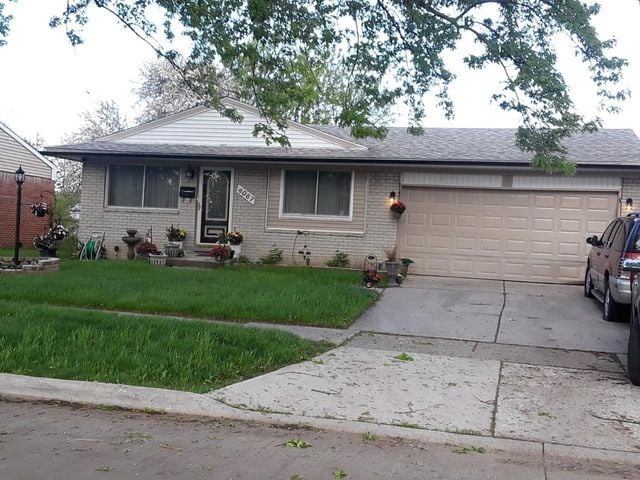 single story home featuring a front yard and a garage