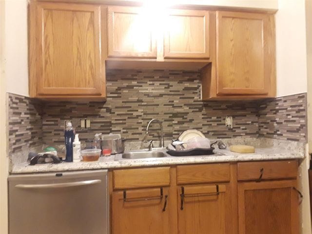 kitchen featuring light brown cabinets, backsplash, and stainless steel dishwasher