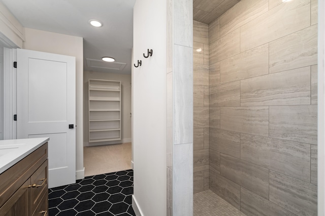 bathroom with tile patterned floors, vanity, and tiled shower