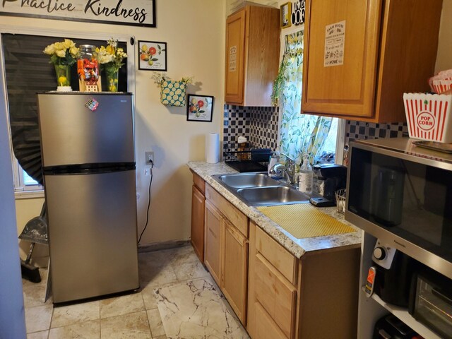 14153 Manning St, Detroit, MI 48205 - kitchen with stainless steel appliances, backsplash, a sink, light countertops, and light marble finish floors