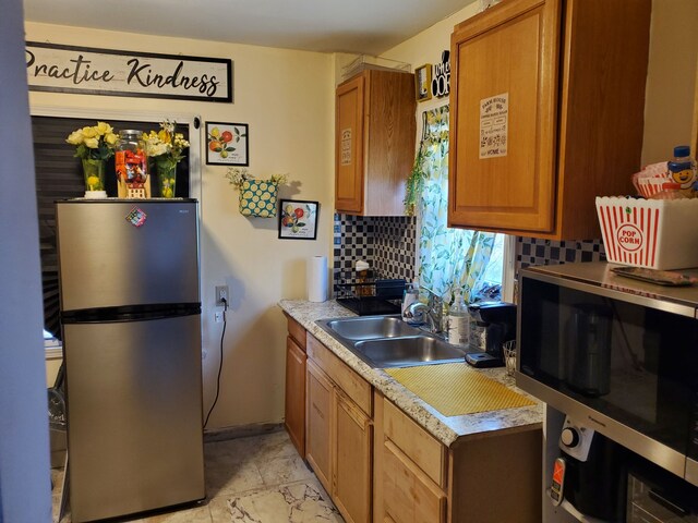 14153 Manning St, Detroit, MI 48205 - kitchen with appliances with stainless steel finishes, decorative backsplash, a sink, light countertops, and brown cabinetry