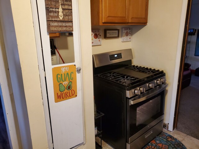 14153 Manning St, Detroit, MI 48205 - kitchen with stainless steel gas stove and brown cabinetry