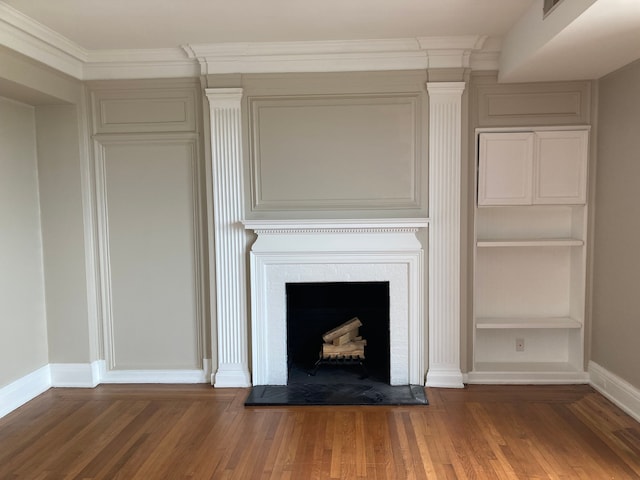 details with built in shelves, ornamental molding, and hardwood / wood-style flooring