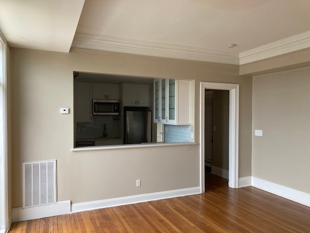 empty room with sink, dark hardwood / wood-style floors, and ornamental molding