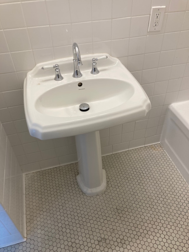 bathroom featuring tile patterned floors, sink, and tile walls