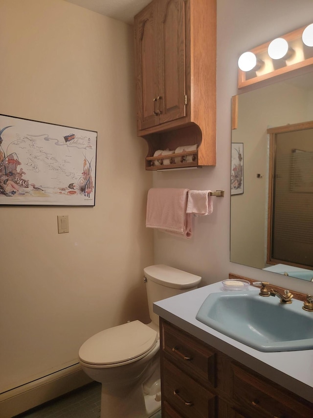 bathroom featuring baseboard heating, vanity, and toilet