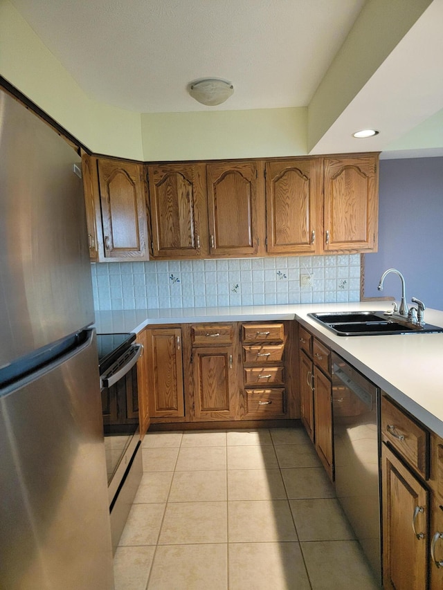 kitchen with decorative backsplash, sink, light tile patterned floors, and stainless steel appliances