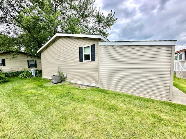 view of side of home with a yard and central air condition unit