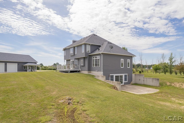 rear view of property featuring a lawn, a patio, and a wooden deck