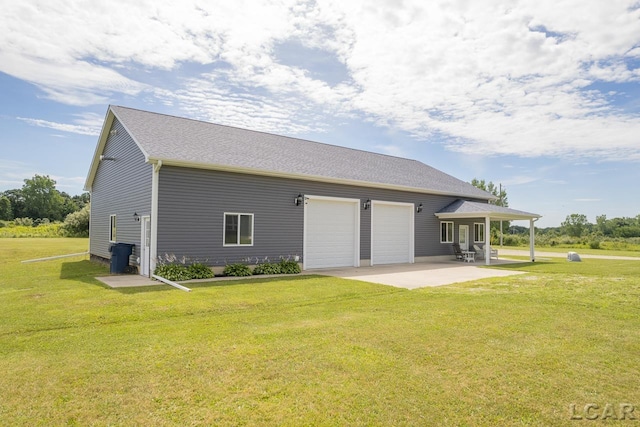 rear view of property featuring a lawn and a garage