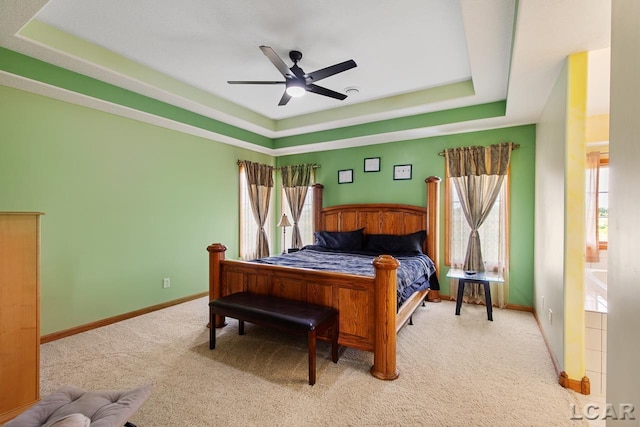 bedroom with a raised ceiling, ceiling fan, and light carpet