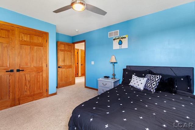 unfurnished bedroom featuring ceiling fan, a closet, and light carpet