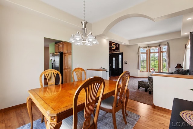 dining space featuring an inviting chandelier and light wood-type flooring