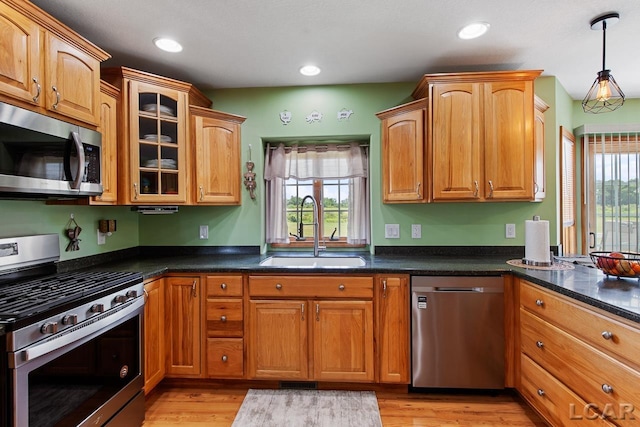 kitchen featuring pendant lighting, sink, light wood-type flooring, and stainless steel appliances