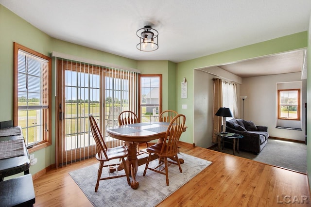 dining area with light hardwood / wood-style flooring, a chandelier, and plenty of natural light