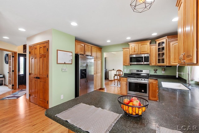 kitchen featuring stainless steel appliances, light hardwood / wood-style flooring, and sink