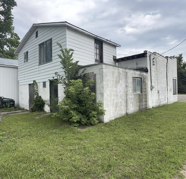 101 N Main St, Hersey, MI 49639 - view of side of home with a lawn and a garage