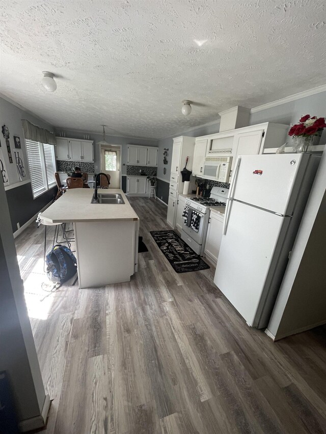 1875 Fire Rd, Twining, MI 48766 - kitchen featuring dark hardwood / wood-style floors, sink, white appliances, and an island with sink