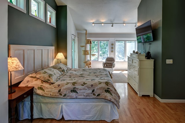 bedroom featuring track lighting and light wood-type flooring