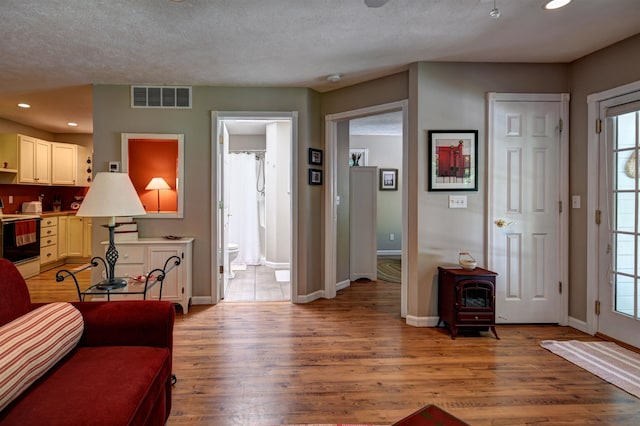 living room with wood-type flooring and a textured ceiling