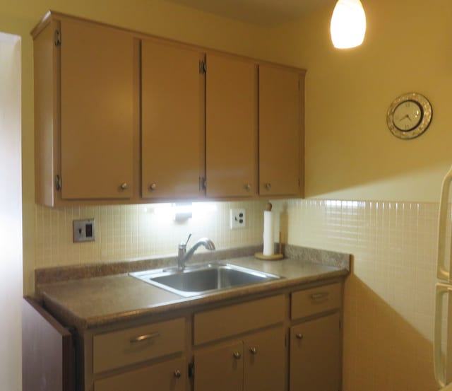 kitchen featuring tile walls, sink, and light brown cabinets