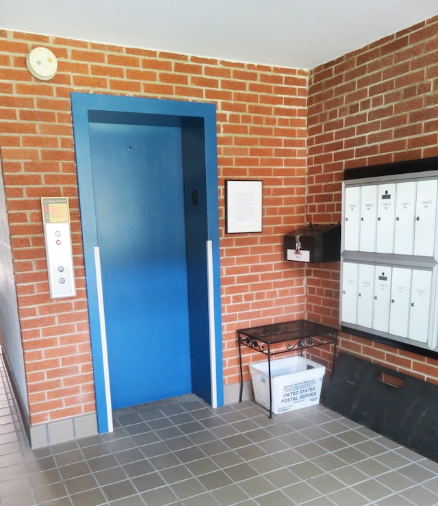 interior space with white cabinets, dark tile patterned floors, elevator, and mail boxes