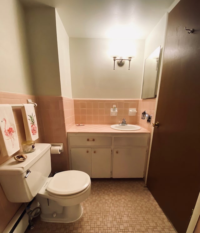 bathroom featuring vanity, toilet, and tile walls