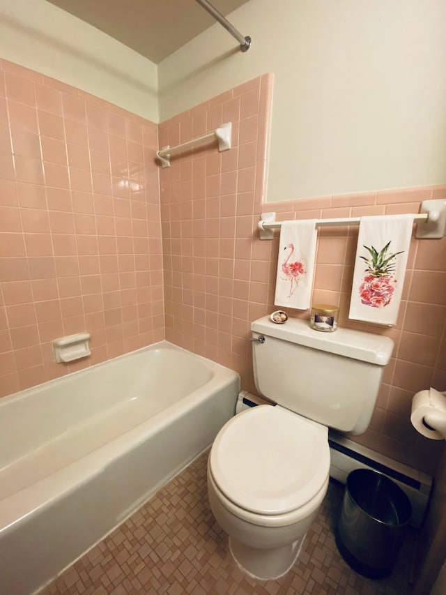 bathroom featuring tile walls, tiled shower / bath combo, tile patterned floors, and toilet