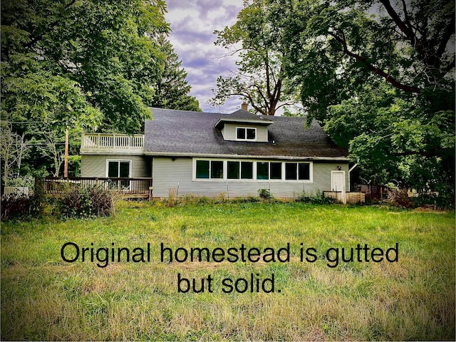 9400 Kruger Rd, Union Pier, MI 49129 - view of front of house with a balcony, a wooden deck, a chimney, and a front lawn