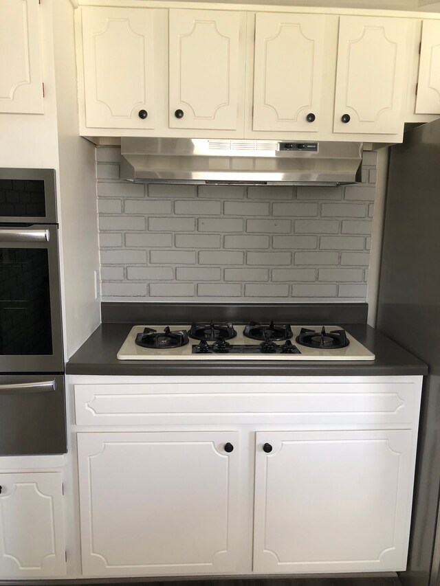 5510 Berkley Dr, Waterford, MI 48327 - kitchen with oven, a warming drawer, under cabinet range hood, and dark countertops